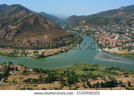 The ancient capital of Georgia Mtskheta on the water of two rivers. Beautiful view of holy city Mtskheta - located on two rivers Mtkvari and Aragvi. The merger of two rivers Aragvi and Kura into one. Royalty-Free Stock Photo #1550908505
