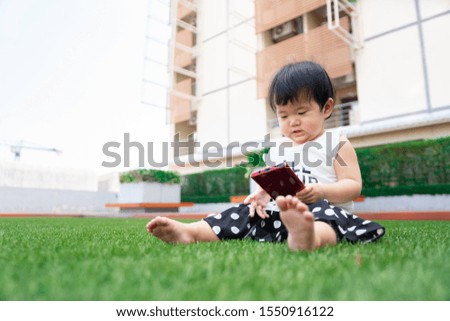 Cute little Asian kid focused on smartphone .  Social and technology concept
