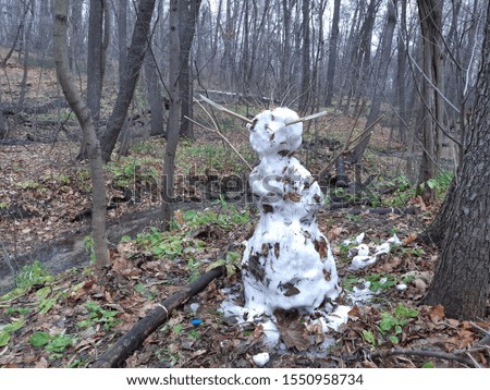 snowman standing in the forest on a warm autumn day