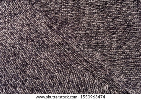 Close-up image of a gray knitwear. The concept of warm knitted homemade things. Advertising space. Background concept. Place for text