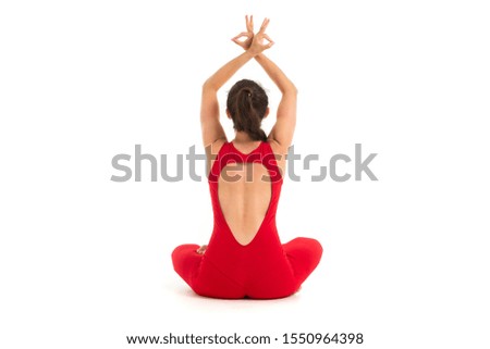Young caucasian gymnast with athletic body sits on a floor, doing yoga and meditating