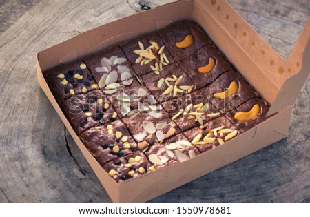 Fudge brownies in a brown paper box on wooden table Royalty-Free Stock Photo #1550978681
