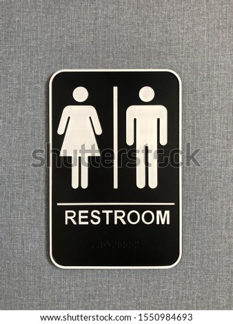 Unisex restroom sign, black and white gender neutral bathroom symbol on blue gray textured background