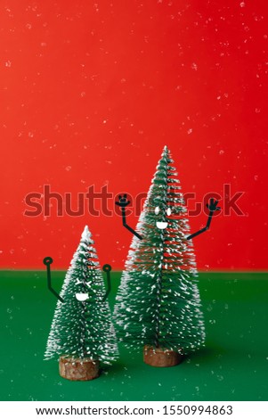 christams tree with smile face emotion doodle style decoration on green table with vivid red background.holiday celebration greeting card with copy space