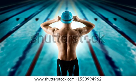 Professional young muscular swimmer jumping from starting block in a swimming pool Royalty-Free Stock Photo #1550994962