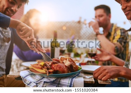 Group of diverse friends having dinner al fresco in urban setting Royalty-Free Stock Photo #1551020384