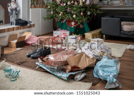 It is holy night. The gifts are unpacked. There is a mess of wrapping paper and boxes throughout the living room. Authentic picture from private party.