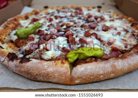 fresh hot meat pizza with green pepper in a box
