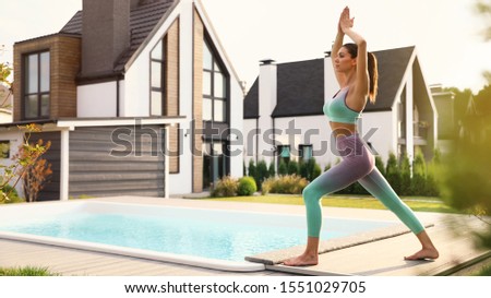 Woman practicing morning yoga near swimming pool. Healthy lifestyle