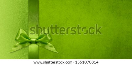 christmas gift card with green ribbon bow on green background, copy space template