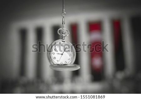 Old pocket watch showing time 9:05 AM, hour of the death of the leader and founder of Turkish Republic in front of blurry Anitkabir mausoleum and people in November 10. 