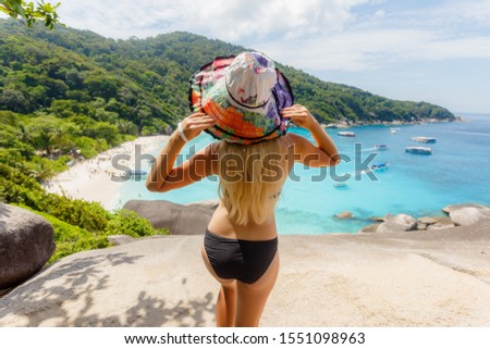 Young female stand on viewpoint sailing rock in Similan island. Freedom traveler woman enjoy a wonderful nature on top mountain with perfect view. travel concept