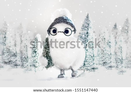 Abominable snowman with glasses stealing Christmas tree in Christmas tree forest 