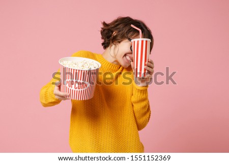 Scared young woman girl in 3d imax glasses posing isolated on pink background. People in cinema, lifestyle concept. Mock up copy space. Watching movie film, holding bucket of popcorn, cup of soda