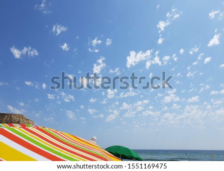 colorful parasol and cloudy sky on Praia da Luz Algarve 