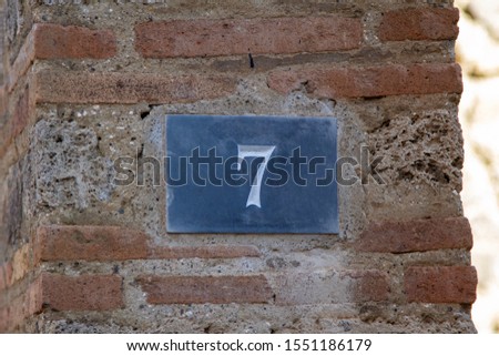 Number 977 on a wall of a house in Pompei Italy 