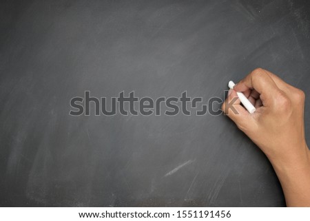 
The man Hand hand holding white chalk writing on blackboard or chalkboard background, concept for education, banner, startup, teaching , etc.