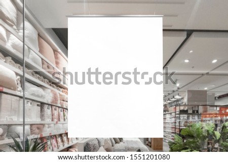 Mockup of blank white vertical indoor advertising poster hanging at the storefront window in shopping centre or mall