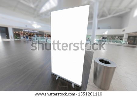 Mockup of blank white vertical indoor advertising roll up stand in shopping centre or mall