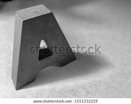 Modern black and white close up detailed dimensional perspective photo of block letter A at an angle with shadow and empty space on the side
