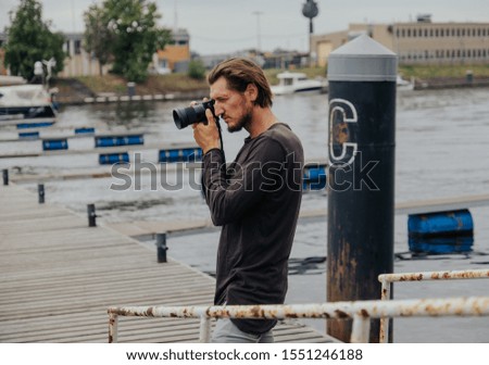 Young hipster photographer with camera and backpack