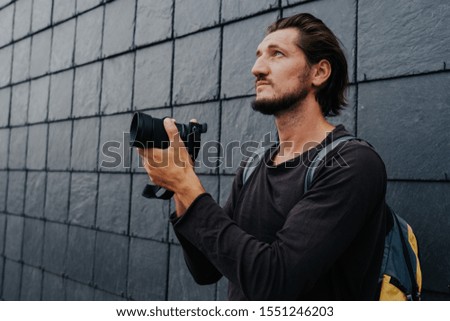 Young hipster photographer with camera and backpack