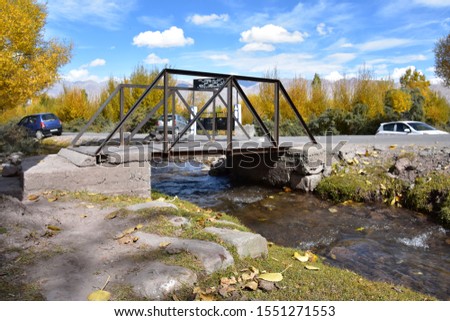A steel bride placed over concrete edge to cross small stream