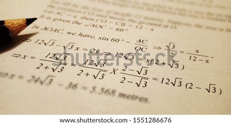 mathematical solution displayed on paper sheet with black pencil pointer 
