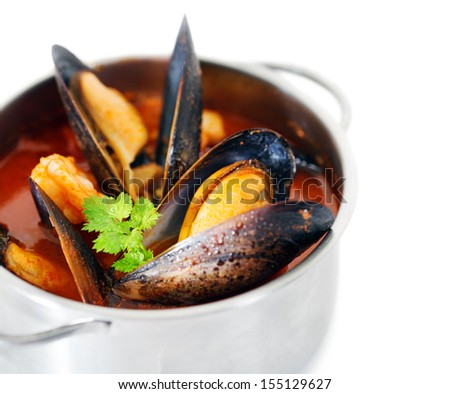 Copper pot of gourmet mussels isolated on white garnished with fresh herbs for a tasty seafood meal