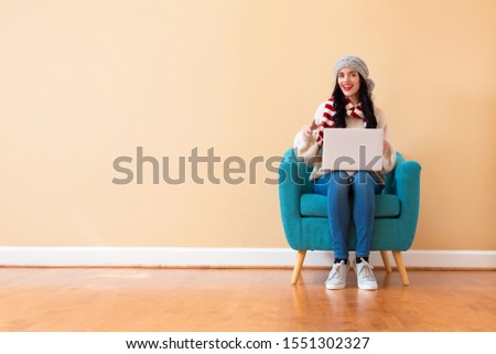 Young woman with a laptop computer sitting in a chair