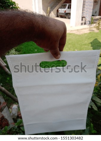 hang with hands White Color D Cut Eco Friendly Non Woven Bag on Green Background