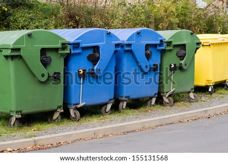 Two blue paper containers, yellow recycling container and two containers for organic waste Royalty-Free Stock Photo #155131568