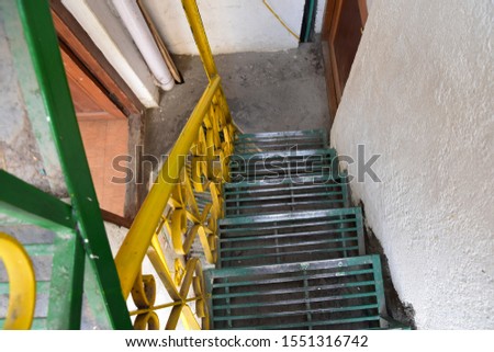 Green and yellow steel stair with grating thread