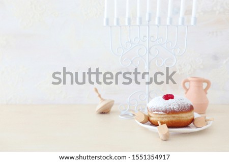 religion image of jewish holiday Hanukkah with menorah (traditional candelabra), spinning top and doughnut over white background