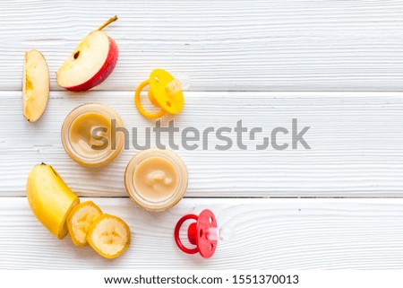 Fruity baby food with apple and banana on white wooden background top view copy space