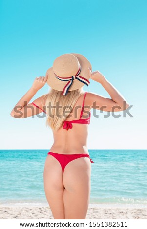 Portrait of a blonde in pink glasses at the sea. A woman walks along the beach and enjoys.