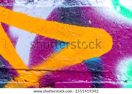 Fragment of colored graffiti painted on a brick wall. Abstract background for design.