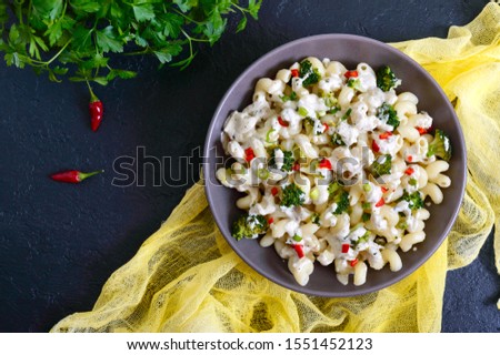Cavatappi pasta with broccoli, red pepper and cream sauce in a bowl. Vegetarian dish. Delicious wholesome food. Proper nutrition. The top view Royalty-Free Stock Photo #1551452123