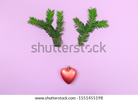 Reindeer face made of Christmas decoration and pine branches. Minimal christmas concept. Flat lay.