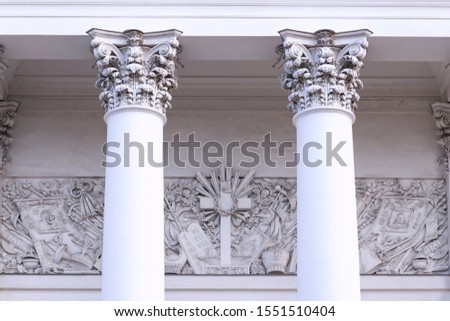 Capitals of columns and a sculpture panel with a religious Christian plot behind them. Translate: repent.