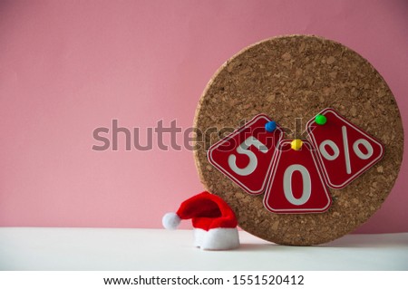 Christmas sale.  Big sale 50%, fifty percent with Santa hat over pink background. 