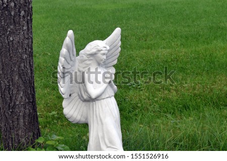 paying angel statue on green grass