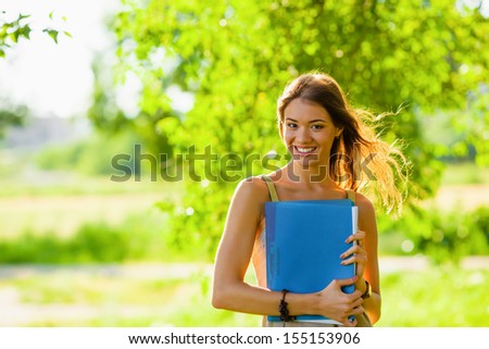 smiling happy student girl portrait holding blue folder