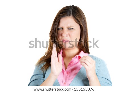 Closeup portrait of a young attractive woman who covers her nose, looks away, something stinks, isolated on white background