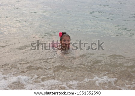 girl with a bow on her hair having fun by the sea
