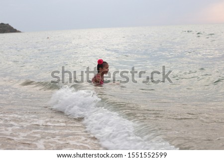 girl with a bow on her hair having fun by the sea