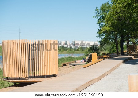Summer park with wooden footpaths and benches.