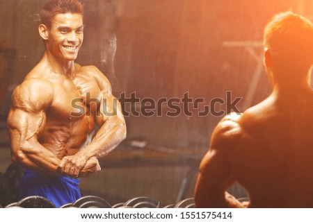 Strong and handsome athletic young man with muscles abs and biceps. Close-up of a power fitness man.