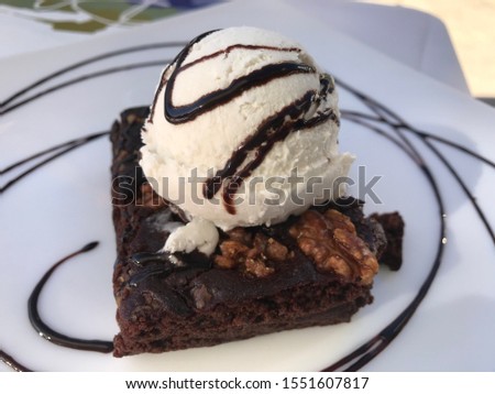 Vegan dessert brownie tart with ice cream. Ice cream is also made from oat. Tasty and healthy dessert without dairy products and eggs. A diet that saves the planet and heals your body. Sweet reward