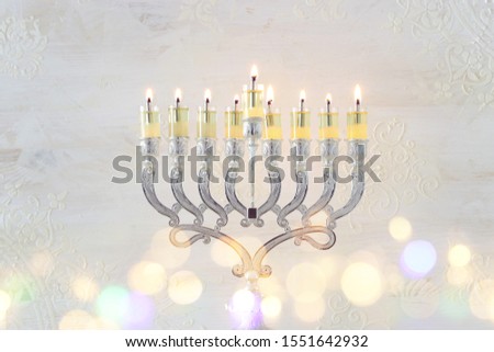 Religion image of jewish holiday Hanukkah with menorah (traditional candelabra) and oil candles over white background